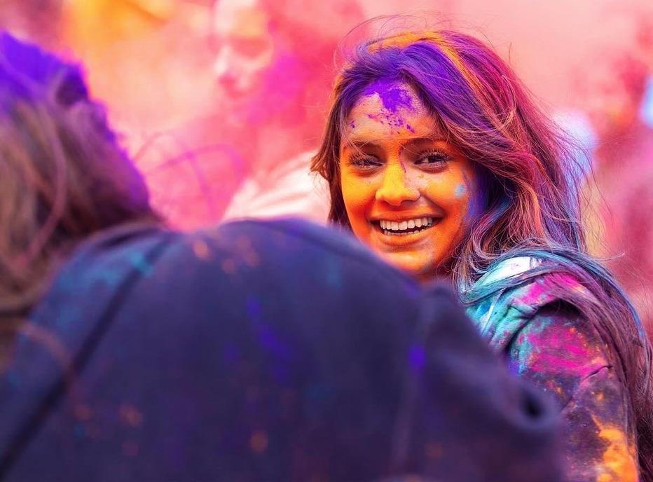 Close up of people at a HOLI festival, very colourful, coloured powder in the air