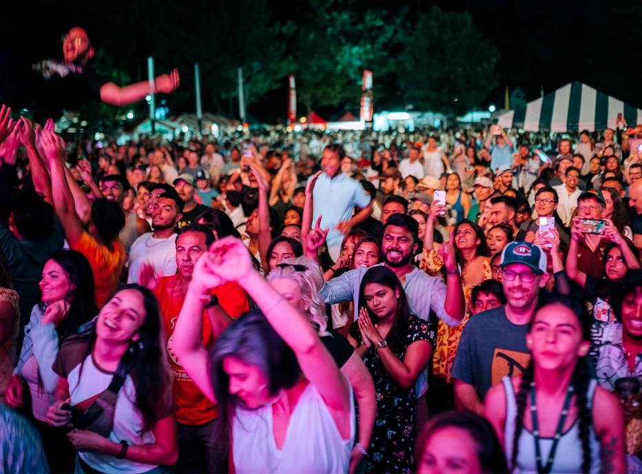 A large crowd of people in Victoria Park in London, Ontario during a summer festival
