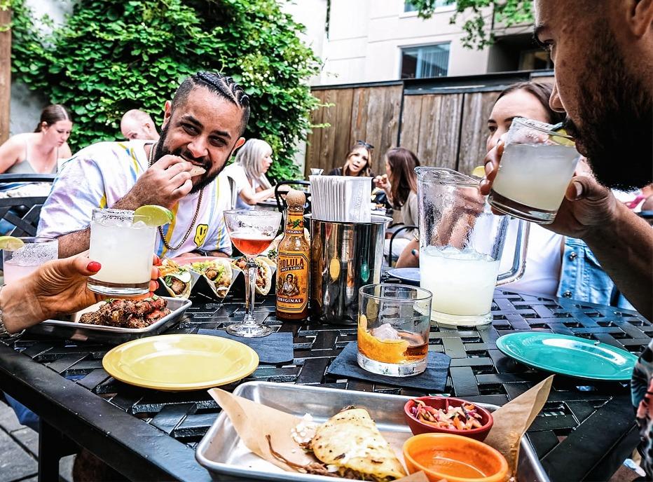 A group of friends dining together outdoors at the Mule located in London, Ontario