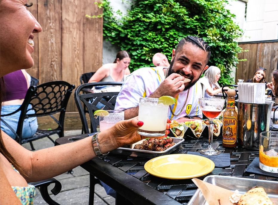 A couple enjoying tacos and beverages at the outdoor patio of The Mule  restaurant in London, Ontario