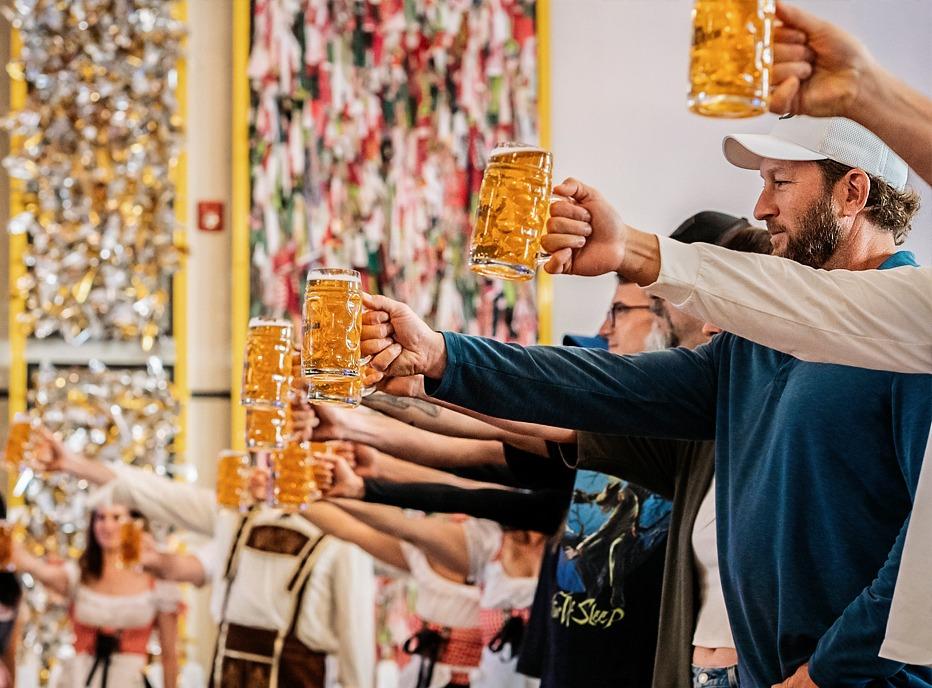 Various people holding up steins of beer at 100 Kellogg Lane located in London, Ontario