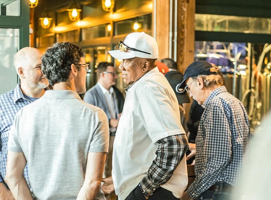 A group of people speaking with Baseball Legend Fergie Jenkins