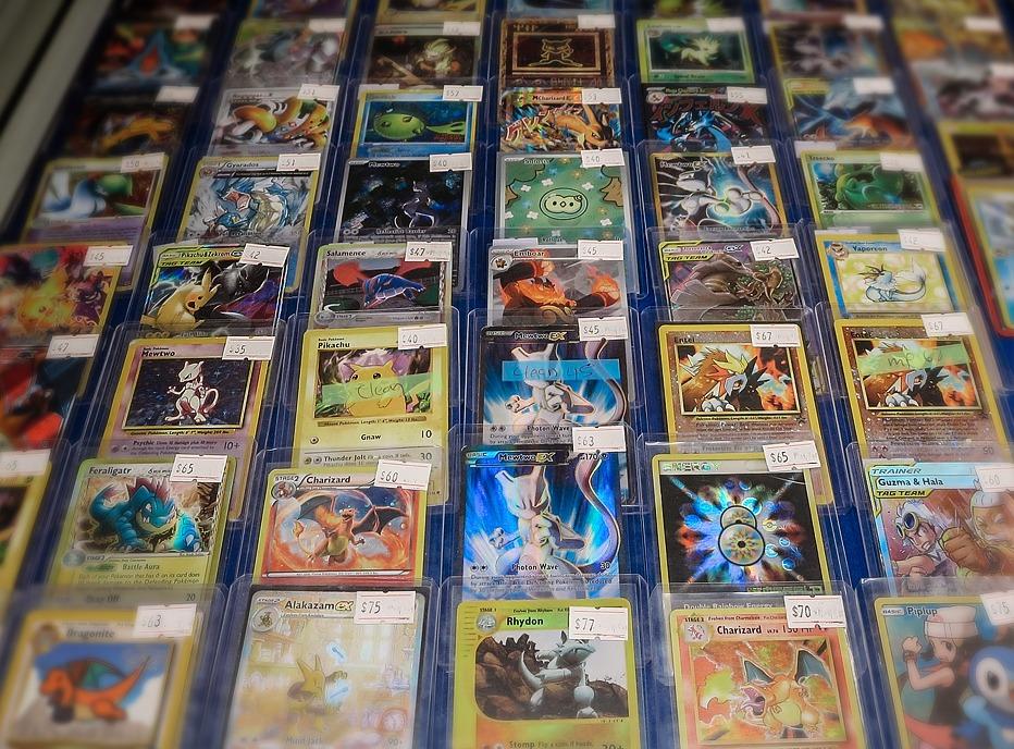 A grouping of rare Pokemon cards on display, covered in a plastic casing with price stickers on them