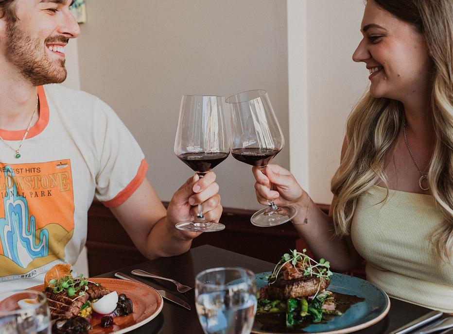 A couple holding their glasses of wine and enjoying a meal at Garlic's Restaurant located in London, Ontario
