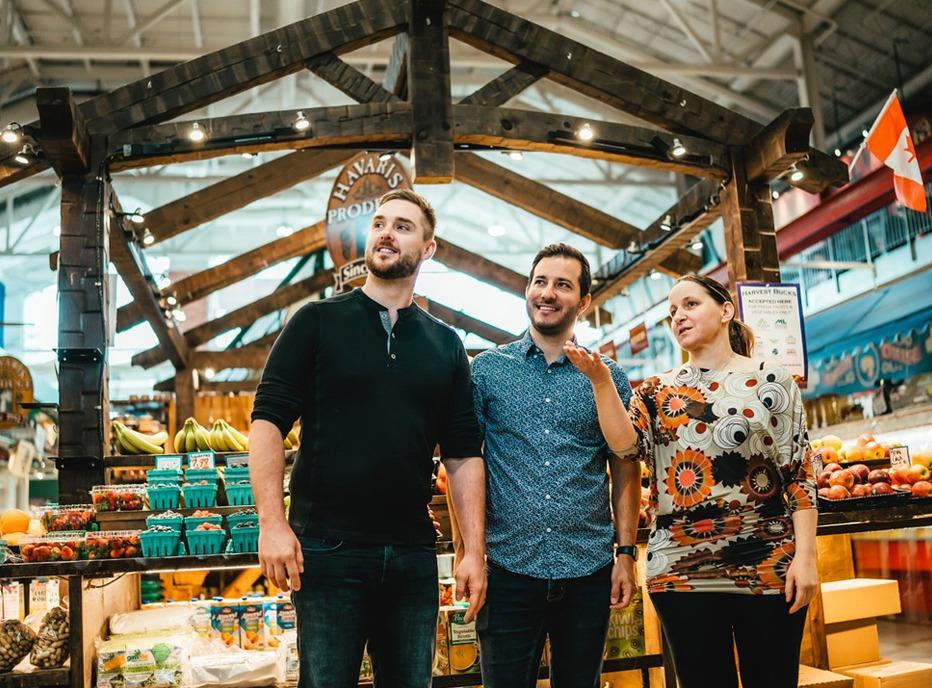 A female is speaking to two males in the middle of Covent Garden Market, located in London, Ontario, Canada