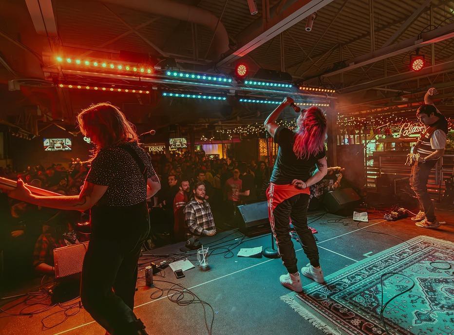 Musicians in a band playing live on stage to a large crowd at Palasad Social Bowl located in London, Ontario