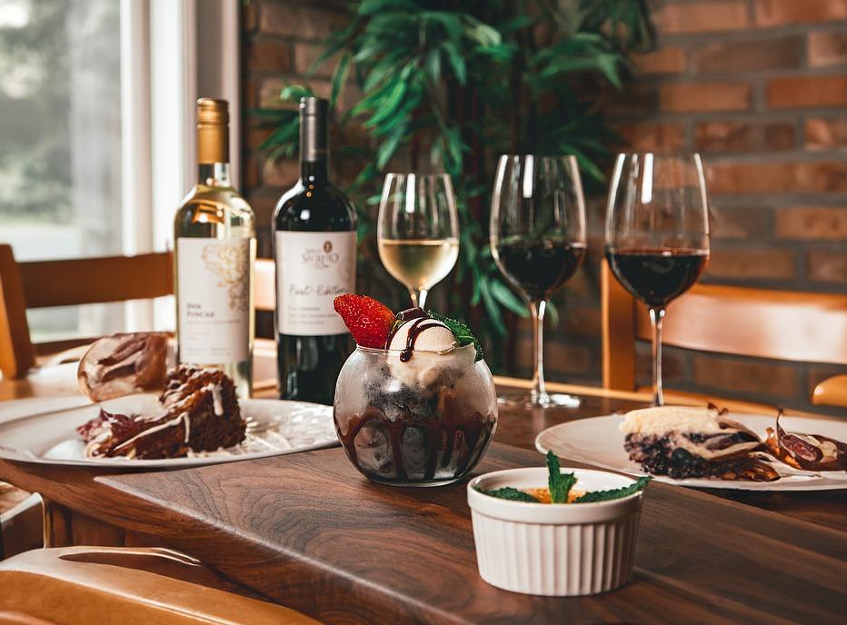 A table setting with various dishes, two bottles of wine and filled glasses from Five87 Bistro, located in London, Ontario