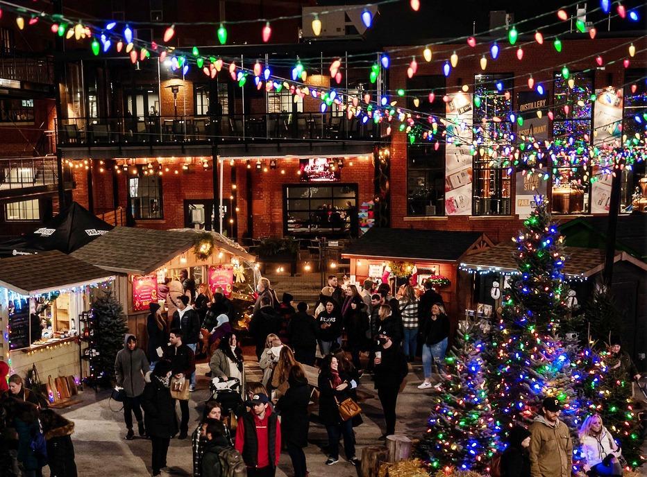 A large group of people gathered outside with various vendors at the Merry Market At 100 Kellogg Lane, located in London, ON