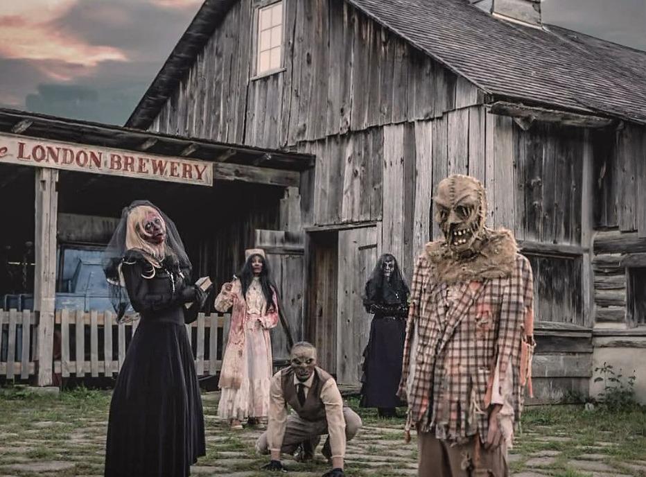 various scary characters in front of an old wooden building at Fanshawe Pioneer Village located in London, Ontario