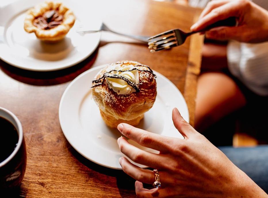 A person about to place their fork into a pastry desert from the Black Walnut Cafe located in London, Ontairo
