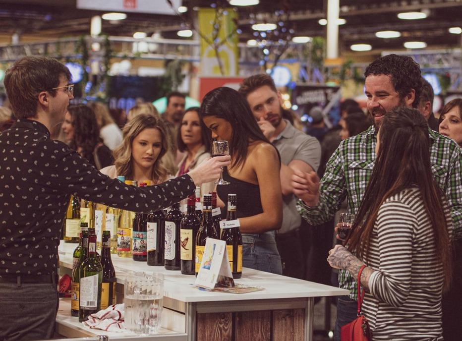 A group of people waiting in line to sample wine from a vendor at the Taste Ex Show in London, Ontario