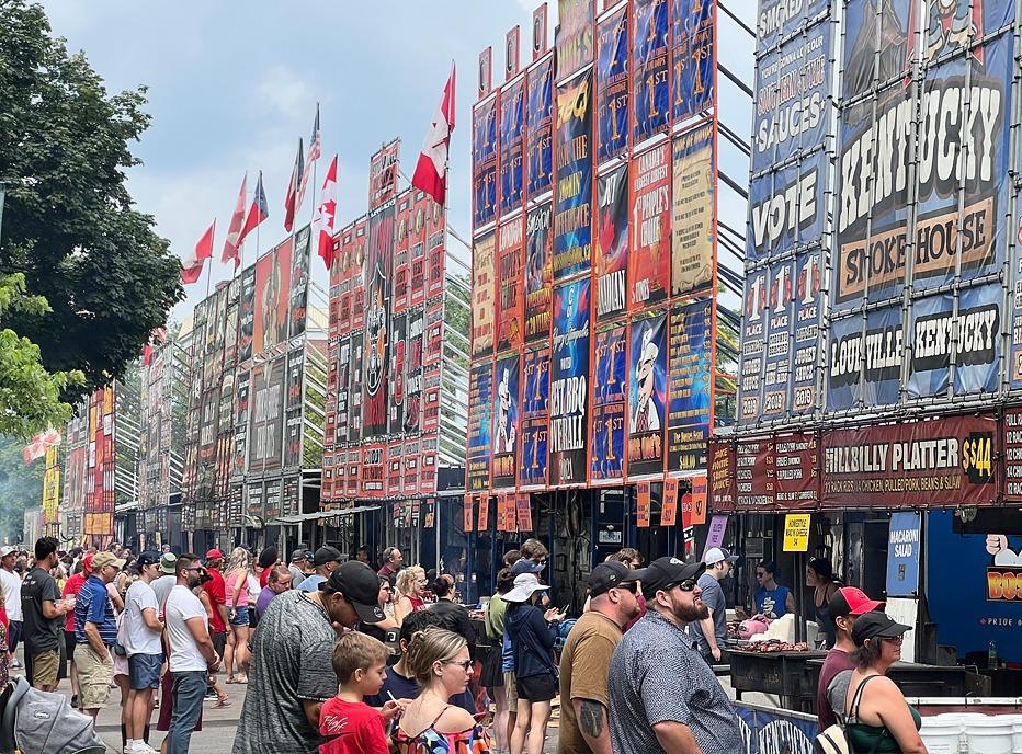 A large crowd gathered, waiting in line to purchase ribs from various vendors at London's Ribfest held in Victoria Park