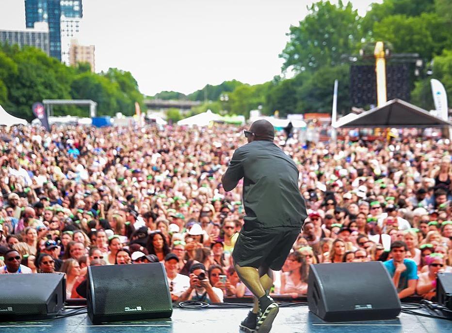 A musician singing to a very large crowd gatered at a Rock the Park Musical Festival held in Harris Park in London, Ontario