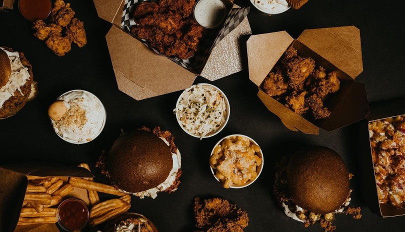 Table spread with fried chicken sandwiches and chicken tenders from BTRMLK located in London, Ontario