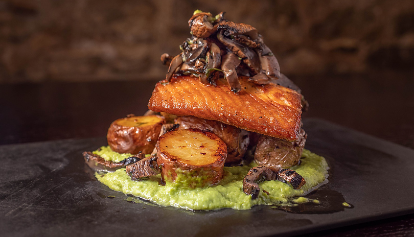 A plate of salmon presented on a stone plate from Church Key Bistro located in London, Ontario