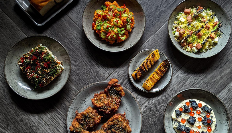 A table top view of various plated dishes from Company Bar located in London, Ontario