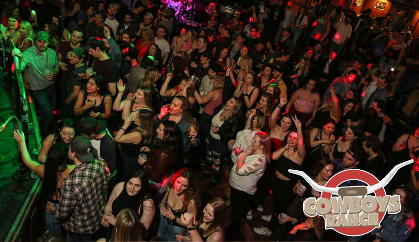 Crowd of people mingling at Cowboy's Ranch bar located in London, Ontario