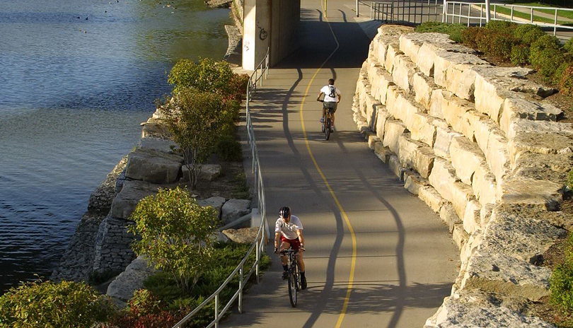 Two people biking down a cycling path in Greenway Park located in London, Ontario