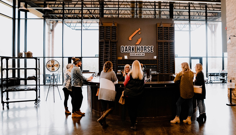 A group of people wine tasting in the main showroom of Dark Horse Estate Winery