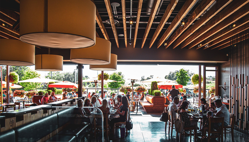 The dining room view inside Dolcetto's restaurant with their patio doors open on a bright summer day