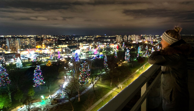 A female viewing Victoria Park's lit up trees for the holidays from the City Hall observation deck in London, Ontario