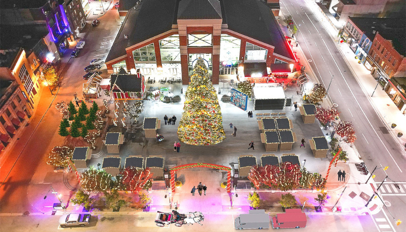 Aerial view of Covent Garden Market outdoors with a large decorated tree lit up for the holidays and various outdoor vendors surrounding it, located in London, Ontario