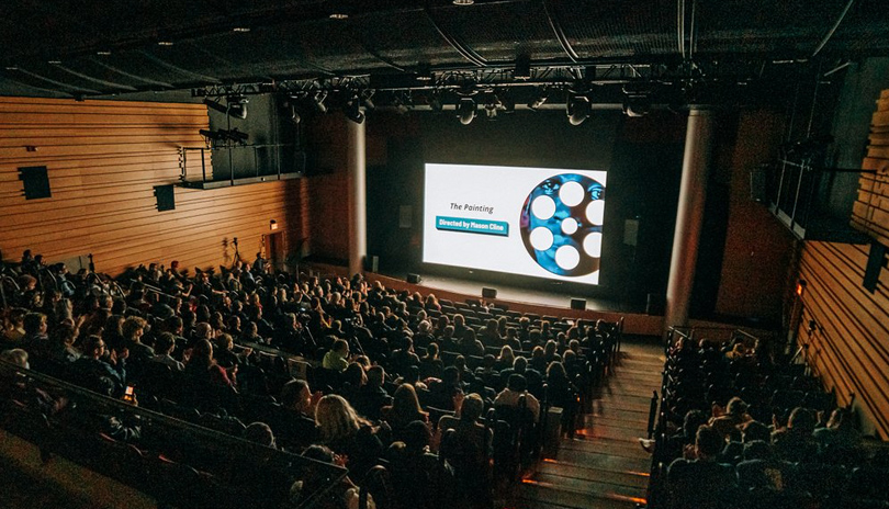 An audience sitting in a theatre at Wolf Performance Hall watching a presentation from the Forest City Film Festival in London, Ontario