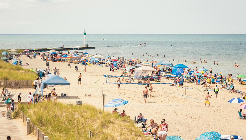 A busy day on Grand Bend's beachfront on a hot summer day with people gathered to swim in the water and play in the sand