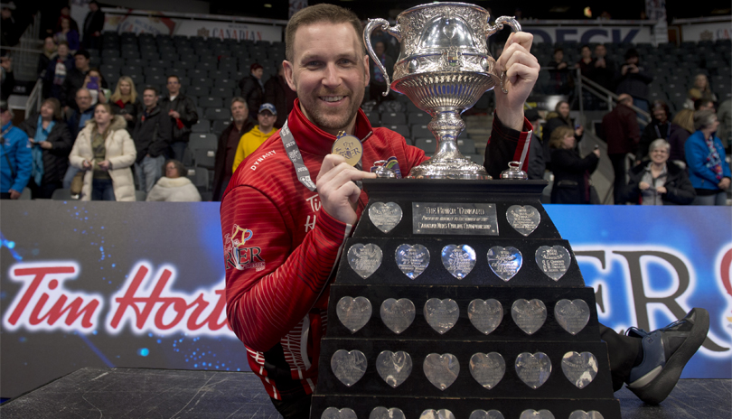 Canadian curler Brad Gushue holding the 2020 Tim Hortons Brier Cup and gold medal