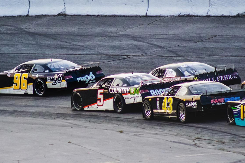 Various Cars racing down a track at Delaware Speedway