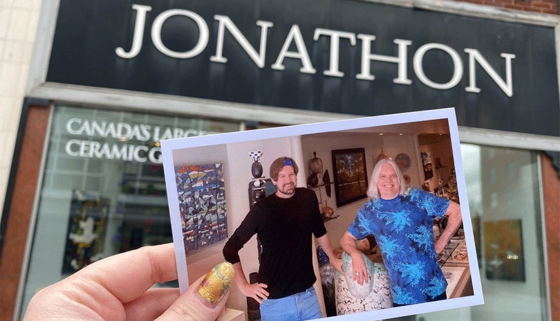 A women holding a polaroid photograph of the owners of Jonathon Bancroft-Snell Gallery in front of their storefront.