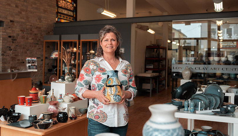 A female holding ceramic pottery in London Clay Art Centre's main showroom located in London, Ontario