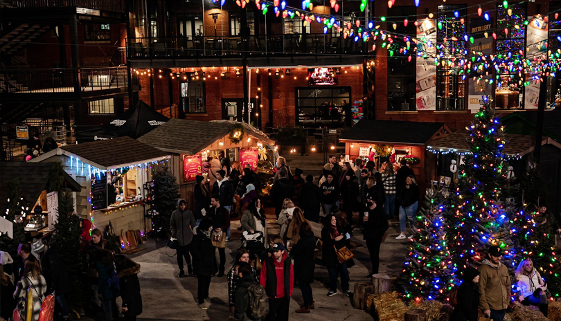 Groups of people at the outdoor Merry Market during the Christmas Holidays with various vendors selling crafts and food at 100 Kellogg Lane in London, Ontario, Canada