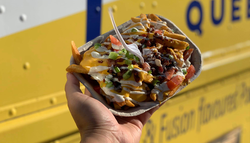 A hand holding food prepared by the Pierogi Queen food truck from London, Ontario