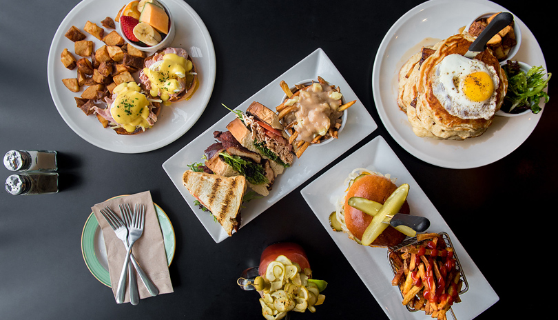 Table top view of various plated dishes from The Early Bird located in London, Ontario