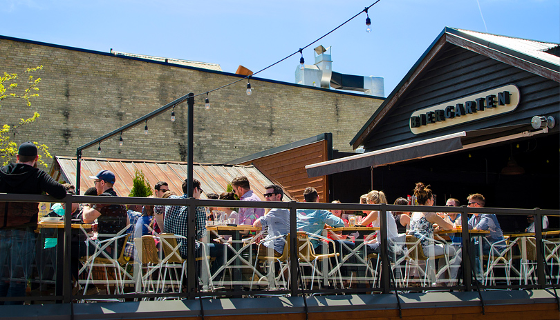 A group of people sitting on a rooftop patio outdoors at Toboggan Brewing Co.  located in London, Ontario, Canada