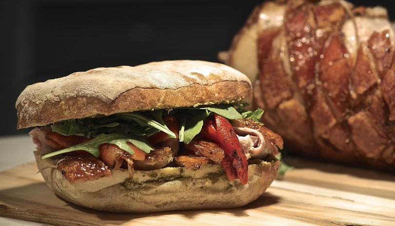 A sandwich resting on a wooden board from Wich is Wich located in London, Ontario