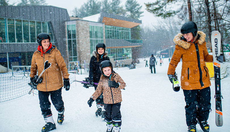 A family with 2 children walking up to a ski hill at Boler Mountain in London, Ontario, Canada
