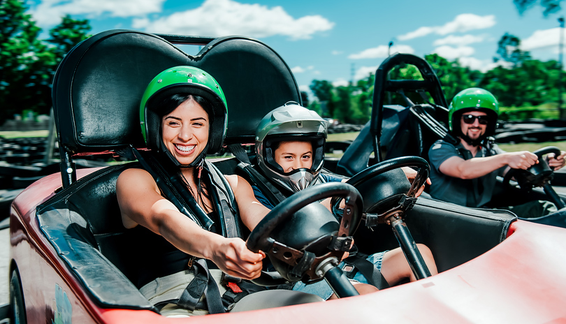 A mother and her son riding in a gocart together and racing down a track at East Park located in London, Ontario