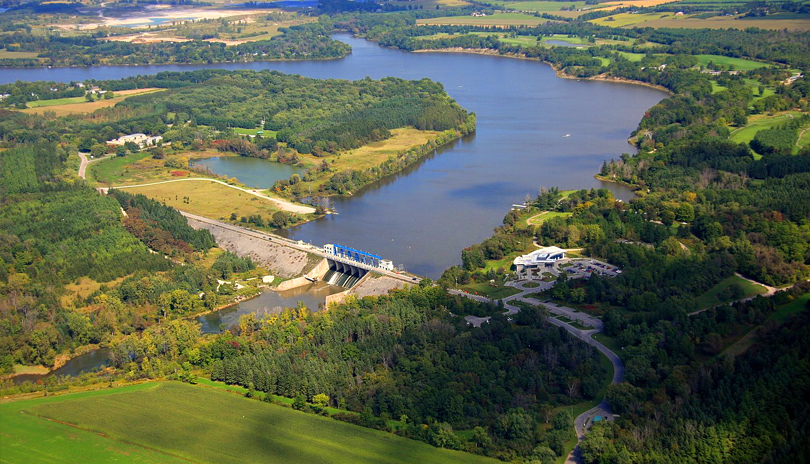 An aerial view of Fanshawe Conservation Area in the summer, with lush trees surrounding a body of water, locate din London, Ontario, Canada