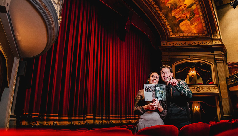 A husband and wife touring the floor level area of the Grand Theatre before a performance located in London, Ontario