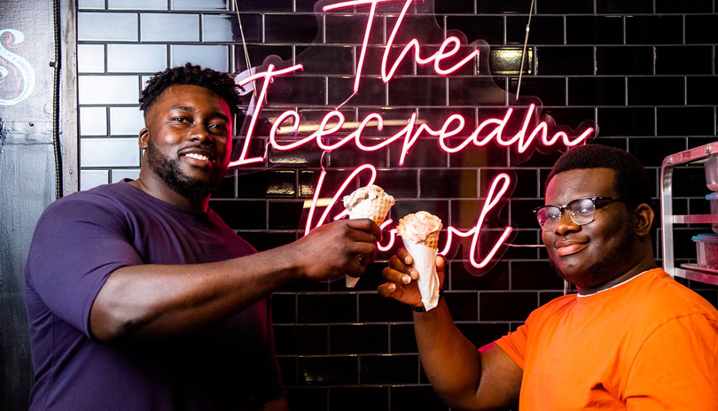 Two males smiling and enjoying an ice cream cone each from The Ice Cream Bowl located in London, Ontario