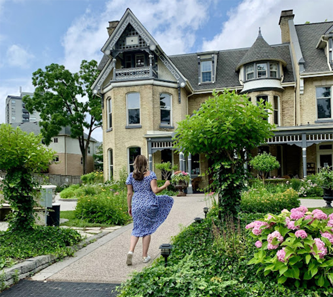 woman in dress posing in front of the Idlewyld inn and spa