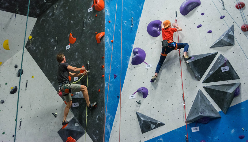 A father and son climbing a wall at Junction Climbing Centre