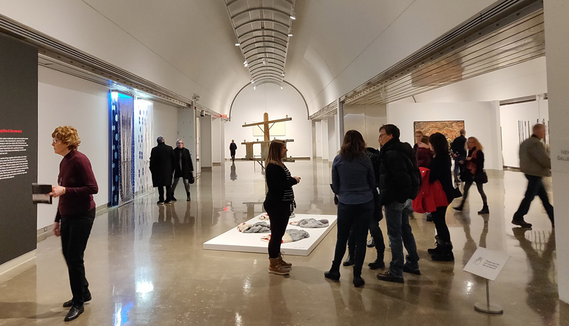 Groups of people looking at various pieces of art on display at Museum London located in London, Ontario