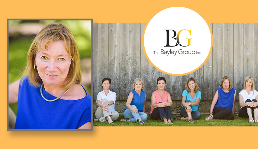 Cass Bayley president of The Bayley Group and group shot of her employees sitting on the grass