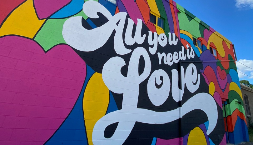 Vibrant and colourful outdoor mural with the words 
