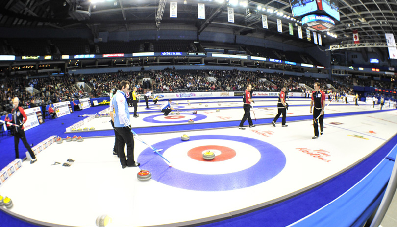 Curlers competing with a large crowd watching at the 2011 Tim Hortons Brier at Budweiser Gardens