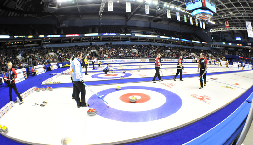 Curlers competing with a large crowd watching at the 2011 Tim Hortons Brier at Budweiser Gardens