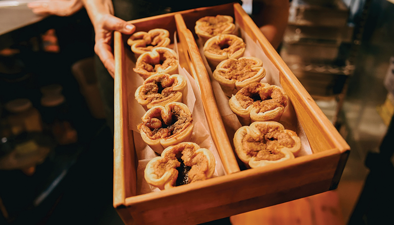 a wooden box filled with 10 freshly baked butter tarts